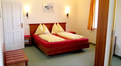 a bedroom with a red bed with yellow pillows at Landhaus Leitner am Wolfgangsee in Sankt Gilgen