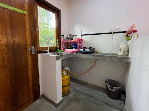kuchnia z blatem, umywalką i oknem w obiekcie Freedom House Hiriketiya w mieście Dickwella