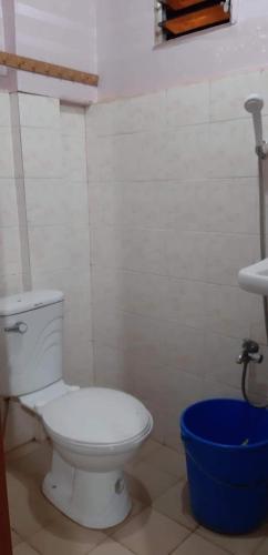 a bathroom with a white toilet and a blue bucket at Mistow Room CDO in Cagayan de Oro