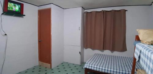 een slaapkamer met een bed, een tv en een raam bij Mistow Room CDO in Cagayan de Oro