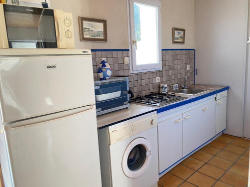Il comprend une cuisine équipée d'un réfrigérateur blanc et d'un lave-linge. dans l'établissement Maison de Vacances Cosy à 800m de la Plage avec Cour Privative et Accès WIFI - FR-1-231-161, à Bretignolles-sur-Mer