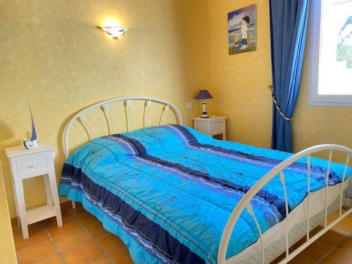 une chambre avec un lit avec une couverture bleue dans l'établissement Maison de Vacances Cosy à 800m de la Plage avec Cour Privative et Accès WIFI - FR-1-231-161, à Bretignolles-sur-Mer