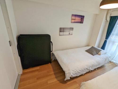 a bedroom with two beds and a greenboard in it at Amber Iidabashi - Vacation STAY 89628v in Tokyo