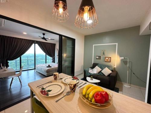 eine Küche und ein Wohnzimmer mit einem Tisch und Obst darauf in der Unterkunft Almas suites Cozy NETFLIX100mbps By STAY in Nusajaya