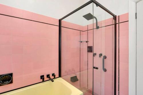 y baño con ducha de azulejos rosados. en Mabel’s retreat 4 bedrooms,Wifi,Netflix,Kayo, en Broken Hill