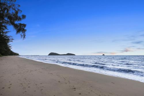 ein Sandstrand mit dem Meer im Hintergrund in der Unterkunft Coral Horizons Ocean View Apartments in Palm Cove
