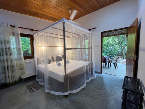 sypialnia z łóżkiem z baldachimem w domu w obiekcie Freedom House Hiriketiya w mieście Dickwella
