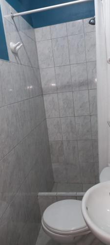a bathroom with a white toilet and a sink at Hostal Aventura in Cajamarca