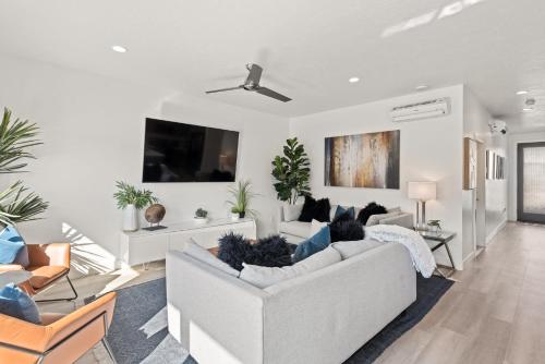 een woonkamer met een witte bank en een tv bij Family Reunion Fun #13 & #15 home in St. George