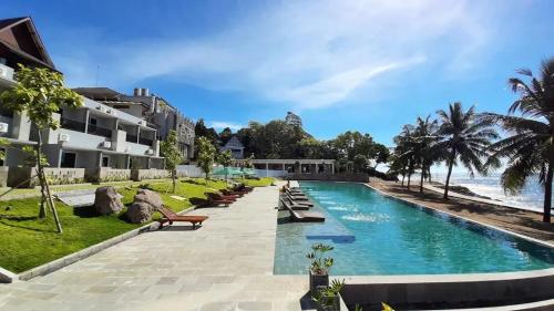duży basen obok plaży z budynkami w obiekcie MaxOneHotels @Anyer w mieście Banten