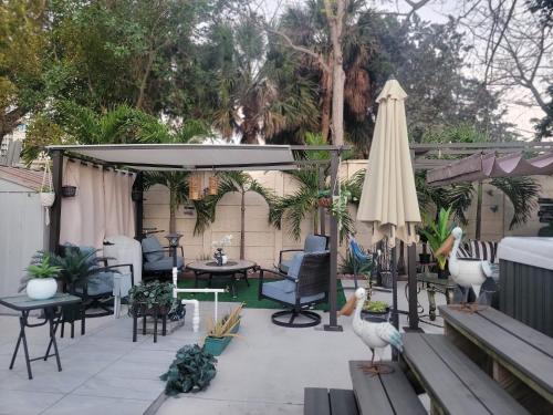 un patio con mesa, sillas y sombrilla en Tiny place w private hot jacuzzi 7 min to Miami international airport, en Miami