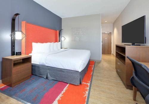 a hotel room with a bed and a flat screen tv at La Quinta Inn & Suites by Wyndham Lakeway in Lakeway