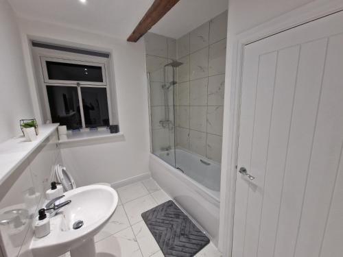 een witte badkamer met een wastafel, een bad en een toilet bij Delightful new period conversion in Burnley