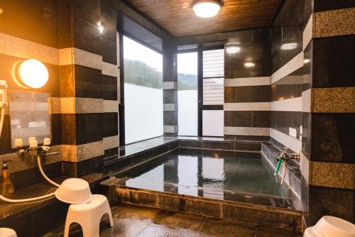 a bathroom with a pool of water in a room at Guest House Takiyoshi in Hongu