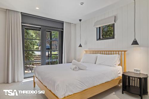 a bedroom with a large bed and a window at Ironmongie 1 JackFrost in Thredbo