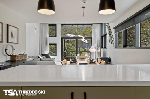 a kitchen and living room with a large white counter top at Ironmongie 1 JackFrost in Thredbo