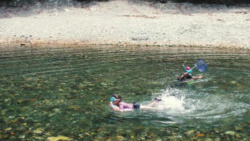 a group of people swimming in a body of water at Guest House Takiyoshi in Hongu