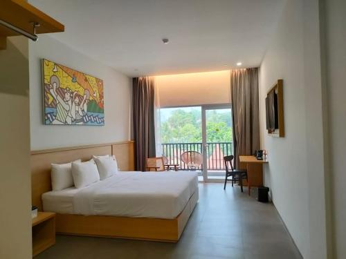 Pokój hotelowy z łóżkiem i balkonem w obiekcie MaxOneHotels @Anyer w mieście Banten