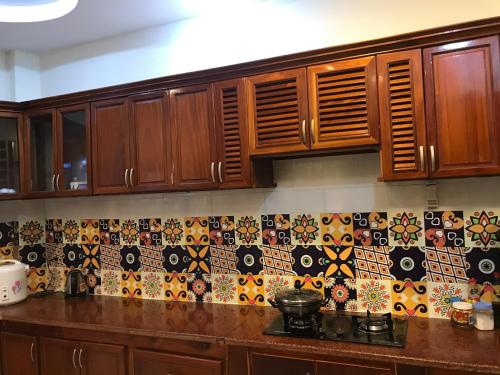 a kitchen with wooden cabinets and tiles on the wall at NHỚ House V in Da Lat