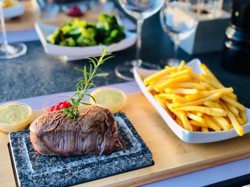 a plate of steak and french fries on a table at perfect lifestyle Design Boutique & Private SPA in Gebenstorf