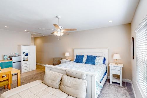 a bedroom with a white bed with blue pillows at Calm Waters - Carriage House in Santa Rosa Beach