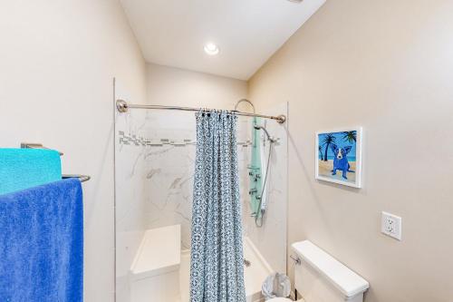 a bathroom with a shower with a blue shower curtain at Calm Waters - Carriage House in Santa Rosa Beach