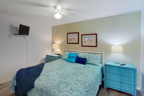 - une chambre avec un lit bleu et 2 tables de chevet dans l'établissement A Place at the Beach 336, à Atlantic Beach