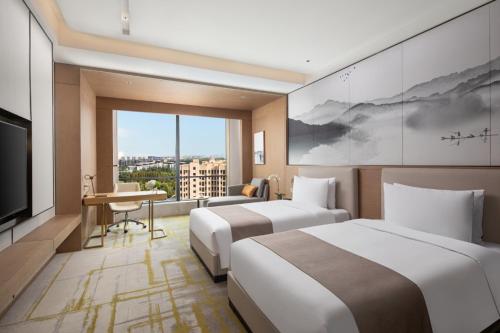 a hotel room with two beds and a television at Metropark Hotel Hongqiao Shanghai in Shanghai