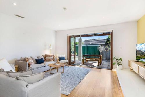 a living room with a couch and a table at Goodie Goodwood Family Home in Unley