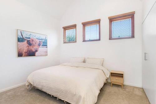 a bedroom with a bed with a picture of a cow on the wall at Goodie Goodwood Family Home in Unley