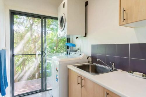 a kitchen with a sink and a dishwasher at Eagles Nest Two Bed Home Nudgee Beach in Brighton