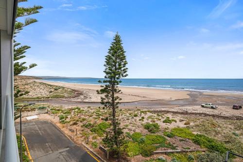 a view of the beach from the balcony of a house at Moana Esplanade - Pure Beach Front 3 Bed Apt in Moana