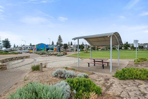 a park with a picnic bench and a canopy at Moana Esplanade - Pure Beach Front 3 Bed Apt in Moana