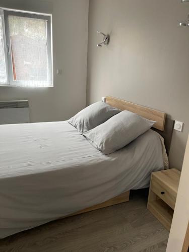 a bedroom with a bed with white sheets and a window at Superbe villa apaisante, vue sur la loue in Mouthier-Haute-Pierre