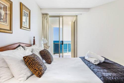 um quarto com uma cama branca e vista para o oceano em Zanzibar-Premium Ocean Apartment em Mooloolaba