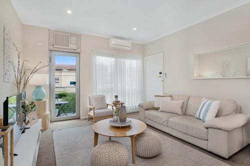 a living room with a couch and a table at Broadway Getaway - 150 Metres to Beach in Glenelg