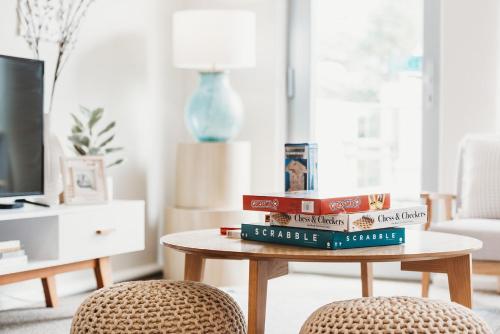 a pile of books sitting on a coffee table in a living room at Broadway Getaway - 150 Metres to Beach in Glenelg