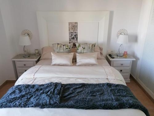 een slaapkamer met een groot bed met een blauwe deken erop bij Apartamento El Portil, Playas del Sur in El Portil