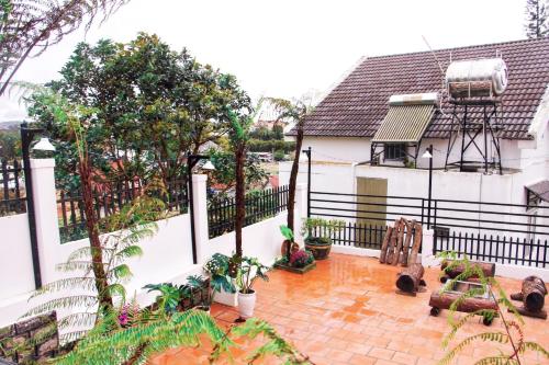 a balcony of a house with trees and plants at NHỚ House V in Da Lat