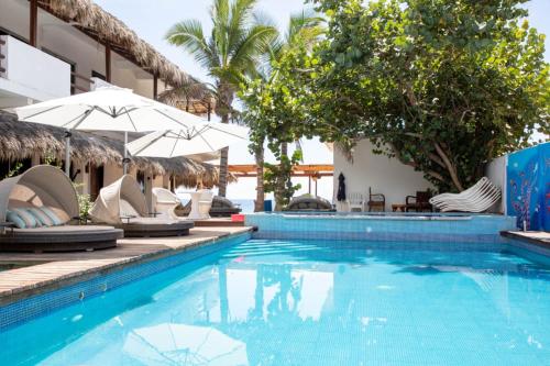 una piscina con sillas y sombrillas junto a un hotel en Hotel Playa Zipolite, en Zipolite
