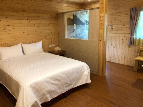 um quarto com uma cama branca num quarto de madeira em Jingshan Landscape em Zhuolan
