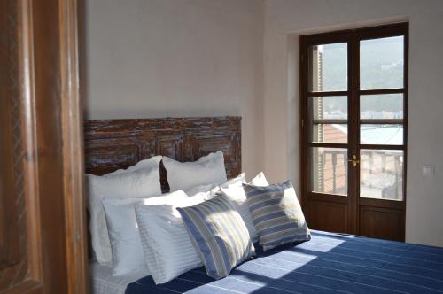 a bedroom with a bed with blue and white pillows at Casa Muse Kastellorizo Whole House in Meyisti