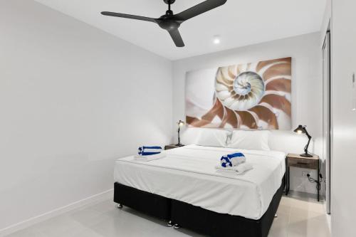 una camera da letto con un letto e un dipinto sul muro di Belle Escapes Oceanview Suite 21 Alamanda Palm Cove a Palm Cove