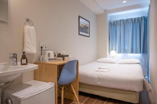 a bedroom with a bed and a desk and a sink at ELE Hotel Ginza East in Tokyo