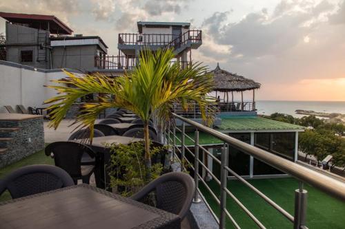 balcón con mesa, sillas y vistas al océano en Hotel Alto Mar, en Catia La Mar