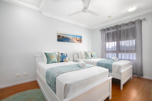 a bedroom with two beds and a window at 604 Chic City Apartment with Water Views in Cairns