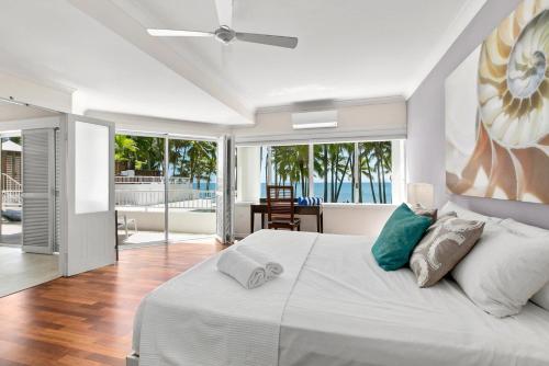 1 dormitorio con cama blanca y vistas al océano en Belle Escapes Oceanview Suite 48 with Private Pool Alamanda Resort Palm Cove, en Palm Cove