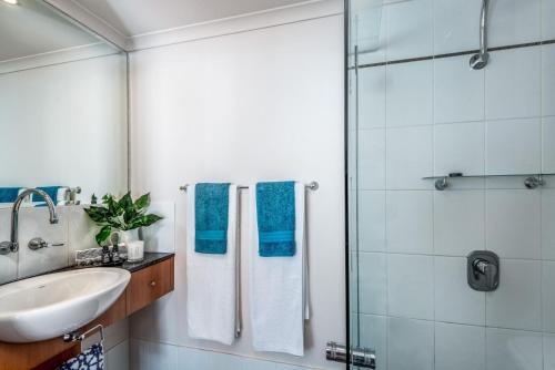 y baño con lavabo y ducha. en Belle Escapes Oceanview Suite 48 with Private Pool Alamanda Resort Palm Cove, en Palm Cove