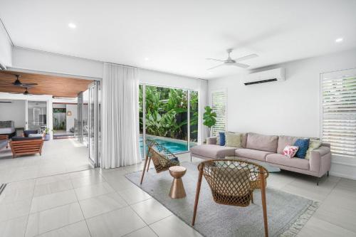 a living room with a couch and a table at Belle Escapes 94 Cascade Luxury Home Palm Cove in Palm Cove