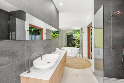 a bathroom with a sink and a shower and a tub at Belle Escapes 94 Cascade Luxury Home Palm Cove in Palm Cove